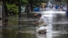 Un vecino destupe una alcantarilla en una calle inundada de El Vedado. (Facebook Canal Caribe)