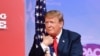 El presidente Donald Trump abraza la bandera de los EEUU, momentos antes de hablar en la Conferencia anual de Acción Política Conservadora (CPAC) en National Harbor, Maryland, el 2 de marzo de 2019.