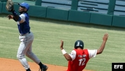 HAB04 - LA HABANA (CUBA), 23/01/05.- El jugador Santiaguero Hector Olivera (dcha), se desliza quieto en segunda, mientras el segunda base de Industriales, Enrique Diaz (izda) trata de alcanzar la pelota hoy, domingo 23 de enero, durante el partido jugado