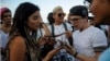 Cubanos verifican conexión a internet en sus móviles durante una prueba de ETECSA.