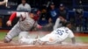El cubano Randy Arozarena (56), de los Rays de Tampa Bay, se roba el home frente al receptor puertorriqueño Christian Vázquez, de los Medias Rojas de Boston, en la Serie Divisional de la Liga Americana en St. Petersburg, Florida, el jueves 7 de octubre de