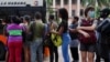 Cubanos hacen fila para subir a un transporte en La Habana.
