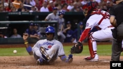 El jardinero derecho de los Dodgers de Los Ángeles Yasiel Puig anota una carrera ante el receptor Tony Cruz (d)