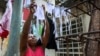 Una mujer tiende nasobucos preparados por ella misma para distribuir entre vecinos del Vedado (Foto: Adalberto Roque/AFP).