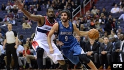 El jugador de Timberwolves Ricky Rubio (d) es marcado por Nene Hilario (i), de Wizards, durante un partido por la NBA, en el Verizon Center de Washington (DC, EE.UU.).