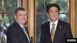 El primer ministro japojés, Shinzo Abe (d), da la bienvenida al presidente del Comité Olímpico Internacional (COI), Thomas Bach.