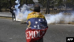 Un manifestante se enfrenta a los soldados de la Guardia Nacional durante las protestas en Caracas.