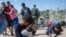 Una familia de migrantes de Venezuela cruza la frontera hacia Estados Unidos por Eagle Pass, Texas, en septiembre de 2023. (Andrew Caballero-Reynolds/AFP)