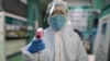 Un técnico de salud se dispone a tomarle la temperatura el jueves en Wuhan a un fotógrafo de la agencia AFP (Foto: Héctor Retamal/AFP).