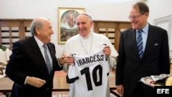 Papa Francisco (c), recibiendo una camiseta con su nombre y el número 10 de manos del presidente de la Federación Internacional de Fútbol Asociación (FIFA), Joseph Blatter (i), durante una audiencia privada en El Vaticano.